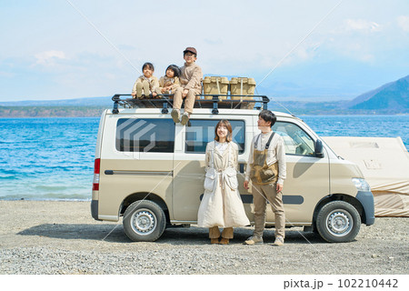 アウトドアを楽しむ家族とキャンピングカー 102210442