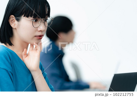 パソコンに向かう若い男女 102212755