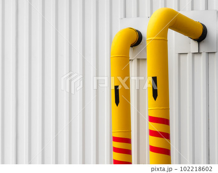 Yellow pipes for transporting gas on white industrial background pointing vertically down Yellow pipes for transporting gas on white industrial background pointing vertically down 102218602