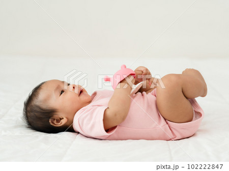 infant baby with mushroom teether rubber toy on bed infant baby with mushroom teether rubber toy on bed 102222847