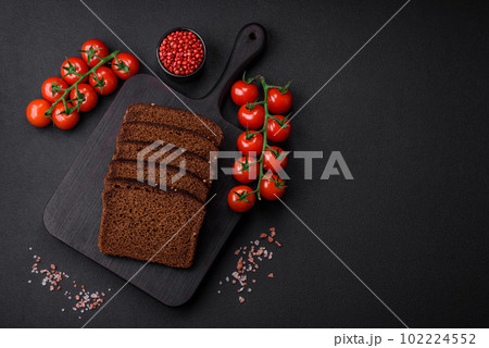 Delicious fresh brown bread with grains and seeds sliced on a wooden cutting board 102224552