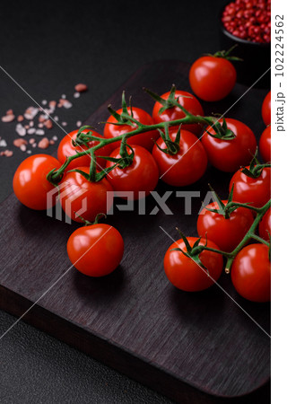 Delicious fresh cherry tomatoes on a twig with spices and herbs Delicious fresh cherry tomatoes on a twig with spices and herbs 102224562