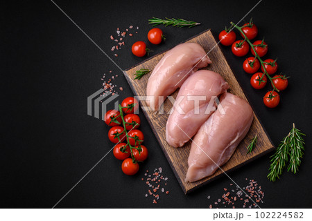 Pieces of raw chicken or turkey fillet with salt, spices and herbs 102224582