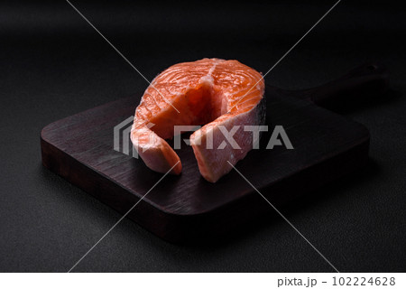 Fresh raw salmon steak with spices and herbs prepared for grilled baking Fresh raw salmon steak with spices and herbs prepared for grilled baking 102224628