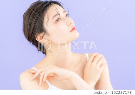 パープルバックでスキンケアをする若い女性 102227178