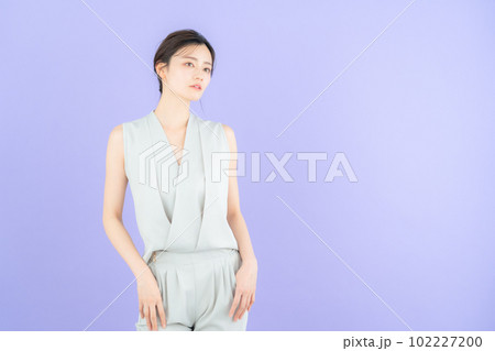 パープルバックでポーズを取る若い女性のファッションモデル パープルバックでポーズを取る若い女性のファッションモデル 102227200