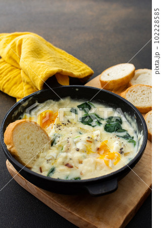 Fried eggs with cheese, spinach leaves 102228585