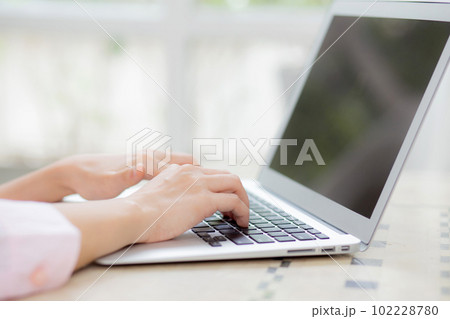Closeup hand of woman typing keyboard on laptop computer on desk at home. 102228780