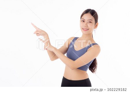 Portrait of beautiful young asian woman in sportwear smile and presenting isolated. 102229182