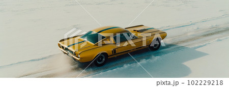 A Cinematic Aerial View of a Yellow Vintage Sports Car Racing Through Snowy Field A Cinematic Aerial View of a Yellow Vintage Sports Car Racing Through Snowy Field 102229218