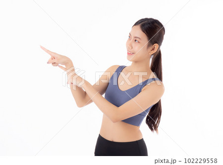 Portrait of beautiful young asian woman in sportwear smile and presenting isolated. 102229558