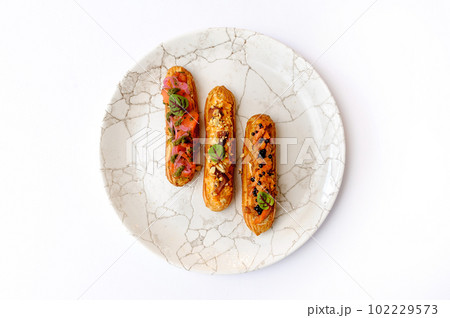 Eclairs with various fillings on a gray plate 102229573