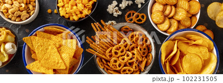 Salty snacks, party mix panorama. An assortment of crispy appetizers Salty snacks, party mix panorama. An assortment of crispy appetizers 102231505