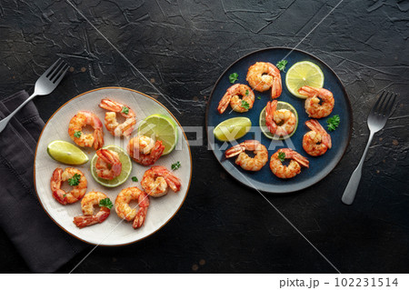 Shrimps, overhead flat lay shot. Fried shrimp with lime, two plates 102231514
