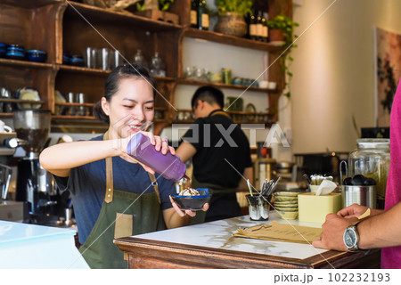 Vietnamese waitress serving ice cream for a customer in a coffee shop Vietnamese waitress serving ice cream for a customer in a coffee shop 102232193