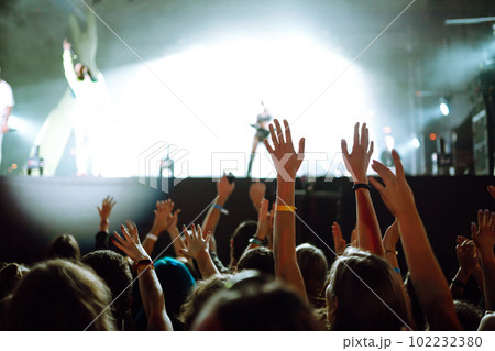 Crowd with raised hands at music festival. Fans enjoying rock concert with light show clapping hands Crowd with raised hands at music festival. Fans enjoying rock concert with light show clapping hands 102232380