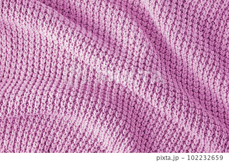 Pink knitted clothes in coarse knit with pleats and shadows as a background for the design Pink knitted clothes in coarse knit with pleats and shadows as a background for the design 102232659