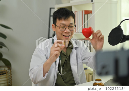 Doctor recording vlog video about medication advise. Healthcare, medicine and blogging concept 102233184