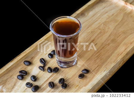 Alcohol shot made of coffee on wooden board with coffee beans with copy space  102233412