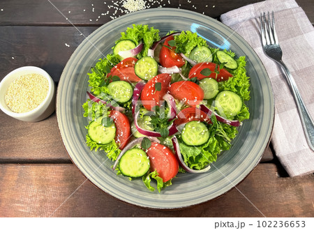Salad of fresh tomatoes and cucumbers in a bowl 102236653