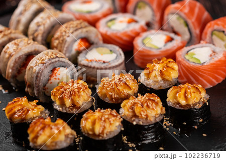 Rolls set with fish shrimp and caviar sushi with chopsticks - asian food and japanese cuisine concept Rolls set with fish shrimp and caviar sushi with chopsticks - asian food and japanese cuisine concept 102236719