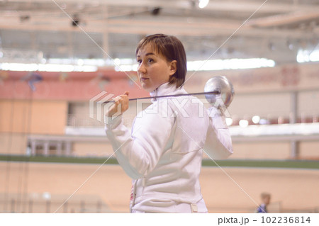 fenser in a white  uniform is training to participate in  a duel 102236814