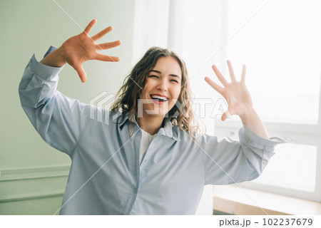 Joyful housewife having fun dancing in the living room, enjoying her free time at home while kids Joyful housewife having fun dancing in the living room, enjoying her free time at home while kids 102237679