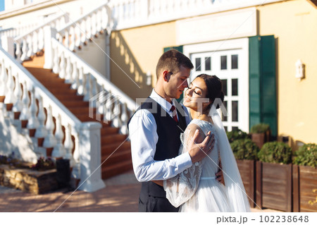 Newlyweds tenderly hug, kiss and enjoy each other. Walk of lovers. Amazing smiling wedding couple. Love. 102238648