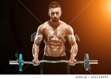 muscular man lifting weights over dark background muscular man lifting weights over dark background 102238954
