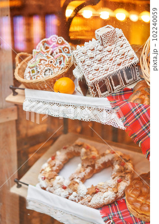 A bakery showcase in a European city for Christmas. Gingerbread house, pretzel, apple crumble, buns. Bread on Christmas and New year 102240059