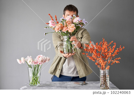 Portrait of a Male florist. Flowers bunch, set for home. Fresh cut flowers for decoration home. European floral shop. Delivery fresh cut flower. 102240063