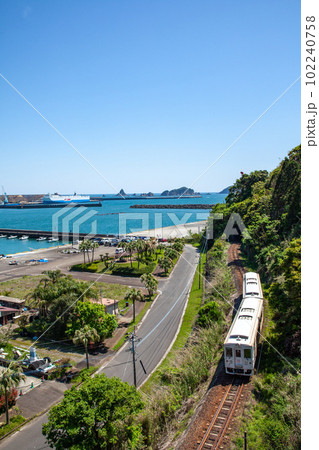 宮崎県日南市油津港を停泊中の船を観ながら港町を走る日南線キハ40 102240758