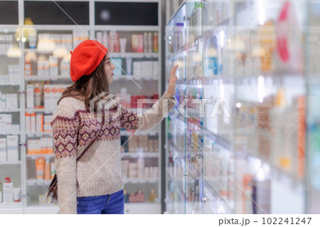 Young woman choosing a medication in pharmacy store. Young woman choosing a medication in pharmacy store. 102241247