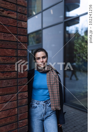 Young woman walking outdoor, in autumn city. 102241256