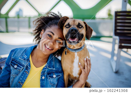 Portrait of happy multiracial girl with her dog. Concept of relationship between dog and teenager, everyday life with pet. Portrait of happy multiracial girl with her dog. Concept of relationship between dog and teenager, everyday life with pet. 102241308