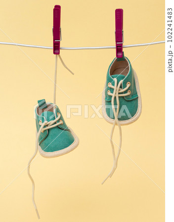 Tiny baby shoes hanging on the clothesline. Newborn concept Tiny baby shoes hanging on the clothesline. Newborn concept 102241483