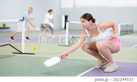 Concentrated young girl pickleball player waiting to receive serve Concentrated young girl pickleball player waiting to receive serve 102244515