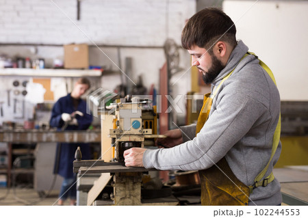 Craftsman working on drilling machine 102244553