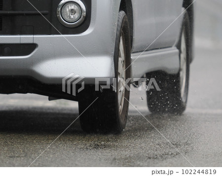 雨の日に濡れた路面を走ってくる乗用車 雨の日に濡れた路面を走ってくる乗用車 102244819
