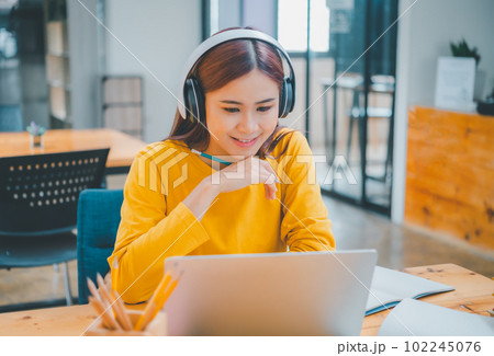 young student wearing headphones studies online, distance learning, and keeps up to date on the global coronavirus pandemic. young student wearing headphones studies online, distance learning, and keeps up to date on the global coronavirus pandemic. 102245076