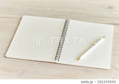 木目のデスクに広げられた新しいノートとボールペン 102245642