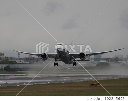 雨の日に水しぶきをあげながら離陸していく旅客機 102245693