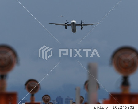 滑走路端の標準式進入灯と離陸していくプロペラ機と遠くに見える着陸してくるジェット機 滑走路端の標準式進入灯と離陸していくプロペラ機と遠くに見える着陸してくるジェット機 102245802