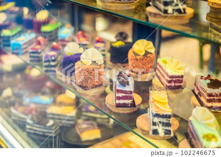 Different types of cakes in pastry shop glass display 102246675