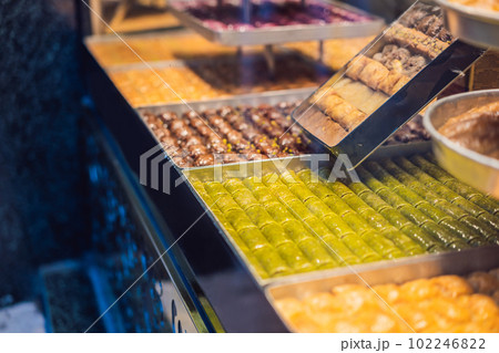 Traditional oriental sweet pastry cookies, nuts, dried fruits, pastilles, marmalade, Turkish desert with sugar, honey and pistachio, in display at a street food market 102246822