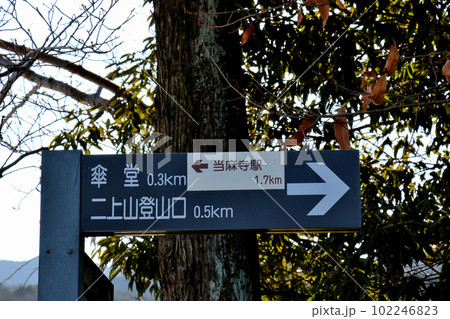 当麻寺駅と傘堂、二条山登山口のそれぞれの方向を示す行先表示板 102246823