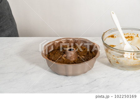 Filling metal bundt cake pan with cake butter to bake gingerbread bundt cake with caramel filling. Filling metal bundt cake pan with cake butter to bake gingerbread bundt cake with caramel filling. 102250169