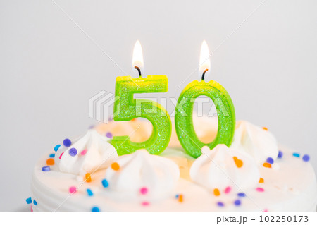 Little birthday cake for 50th birthday on a white cake plate. 102250173