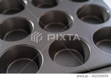 Close-up view. Metal baking pans for cupcakes on a marble countertop. Close-up view. Metal baking pans for cupcakes on a marble countertop. 102250450
