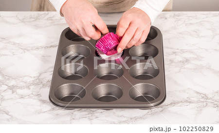 Step by step. Baking chocolate cupcakes. Lining metal cupcake pan with foil cupcake liners. Step by step. Baking chocolate cupcakes. Lining metal cupcake pan with foil cupcake liners. 102250829